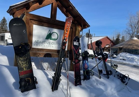 Adaptive Outdoors sign and snowboarding equipment