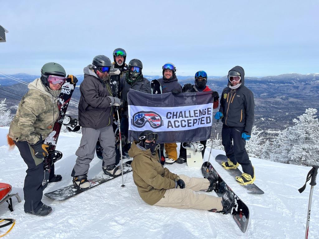 Snowboarders holding banner